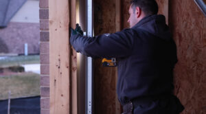 the man is grinding the metal of the garage door