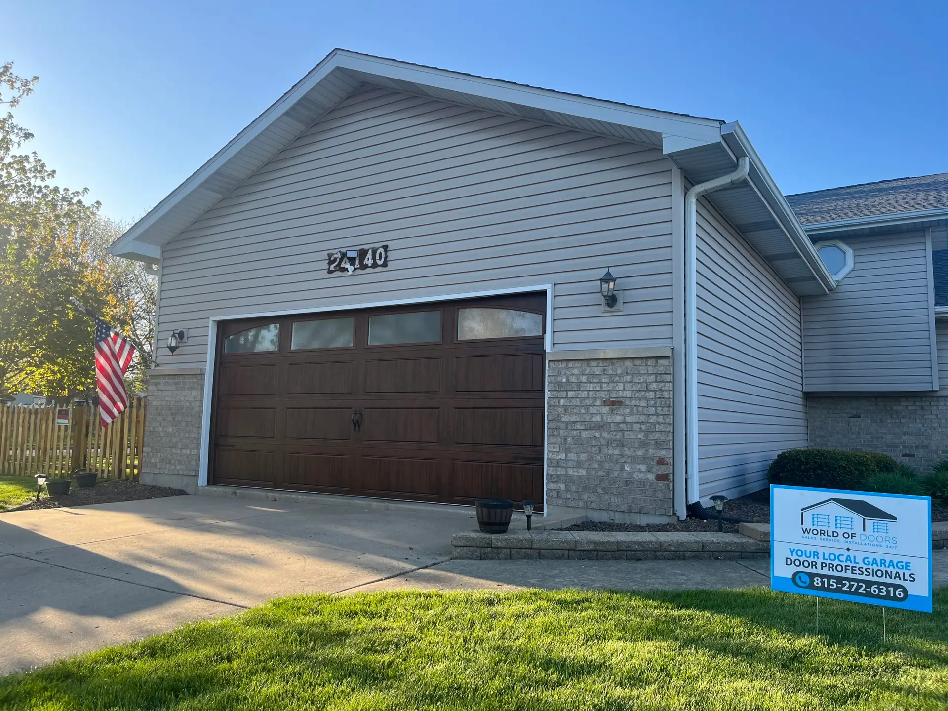 A newly installed wooden-style garage door enhances curb appeal and security. Replace your garage door today.